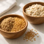 Bowl of ground flaxseed and whole flax seeds on a kitchen table with oatmeal