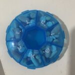 A round blue weekly pill organizer with a compartment for each day