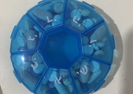 A round blue weekly pill organizer with a compartment for each day
