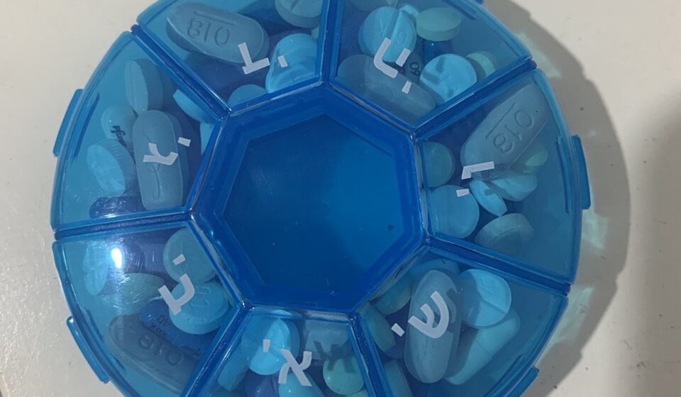 A round blue weekly pill organizer with a compartment for each day