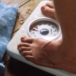 A person standing barefoot on a bathroom scale