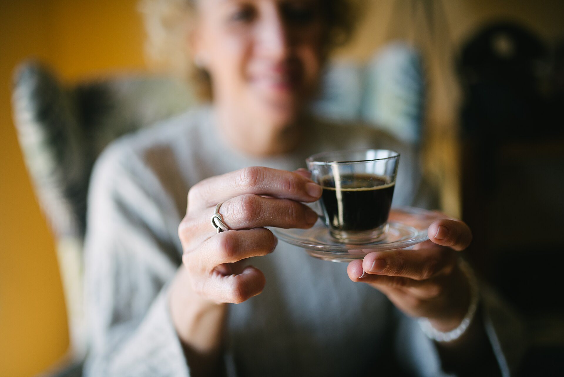 Smiling senior woman holding a glass of espresso
