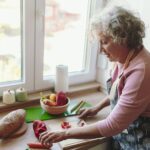 Senior woman chopping vegetables at her kitchen counter