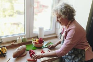 Senior woman chopping vegetables at her kitchen counter