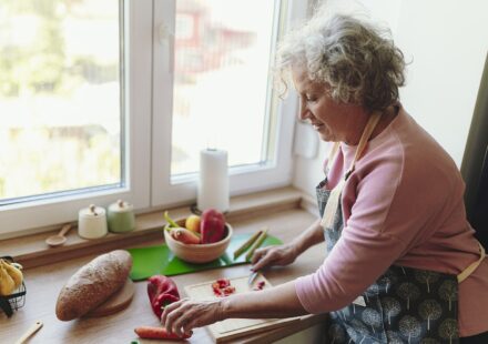 Senior woman chopping vegetables at her kitchen counter
