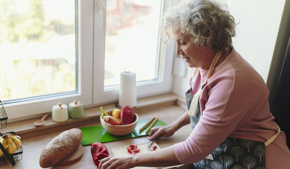 Senior woman chopping vegetables at her kitchen counter