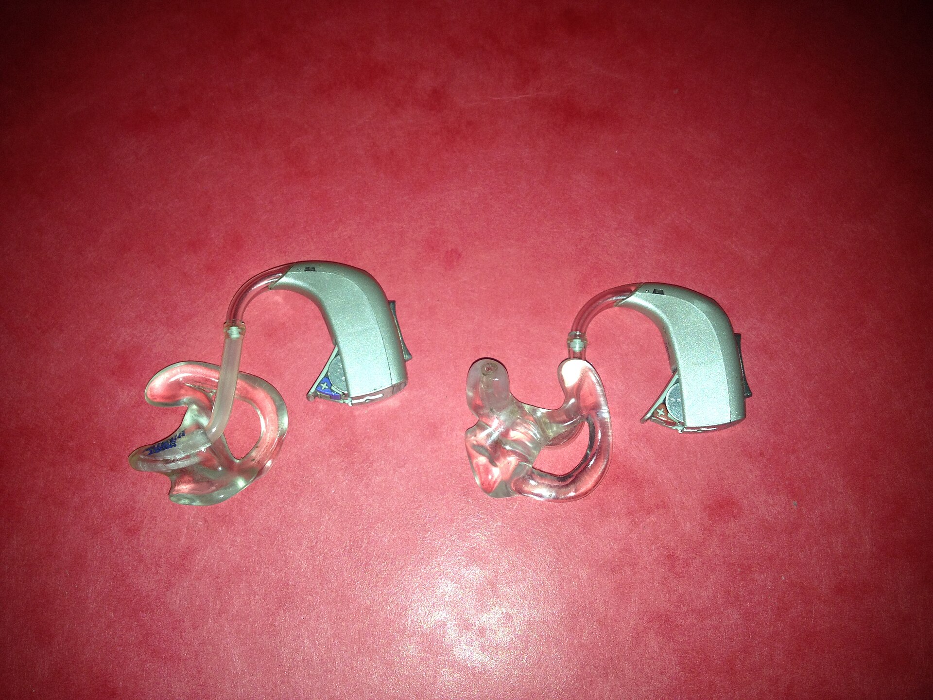 Two behind-the-ear hearing aids on a table