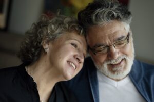 Older couple smiling and leaning their heads together