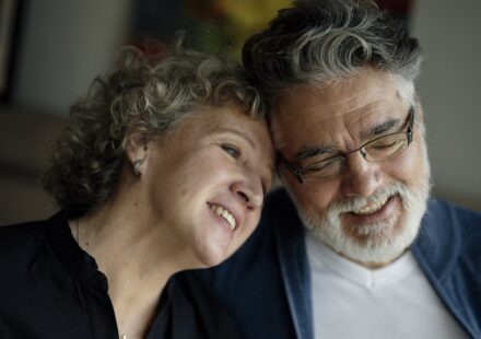 Older couple smiling and leaning their heads together