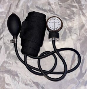 An aneroid blood pressure cuff with gauge and inflation bulb