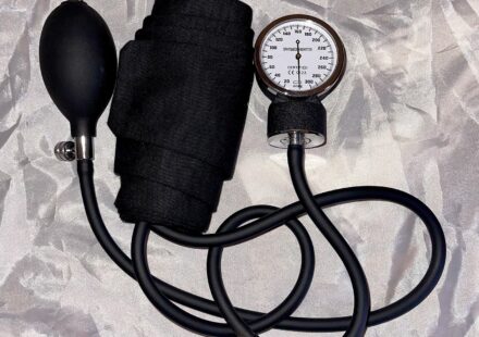 An aneroid blood pressure cuff with gauge and inflation bulb