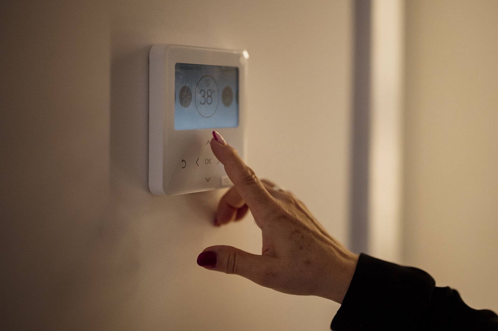 Hand adjusting a home thermostat