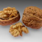 Whole walnuts and an opened walnut showing the kernel