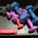 Colorful dumbbells of various sizes on a rack