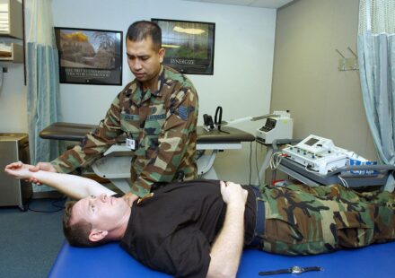 A physical therapy technician helping a patient exercise an injured shoulder