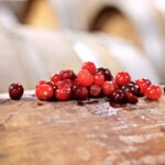 A small pile of red Montmorency and darker Balaton tart cherries on a wooden barrel top