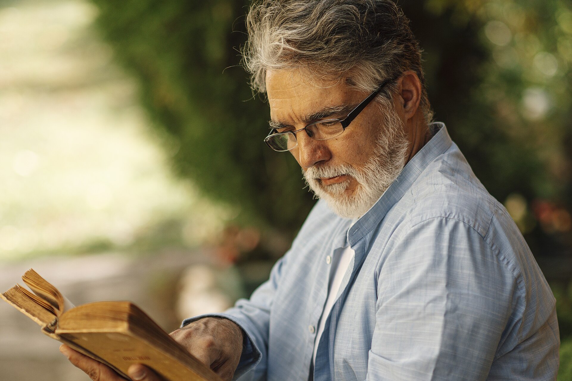 Senior man reading a book outdoors