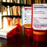Red prescription bottles with pharmacy labels on a table