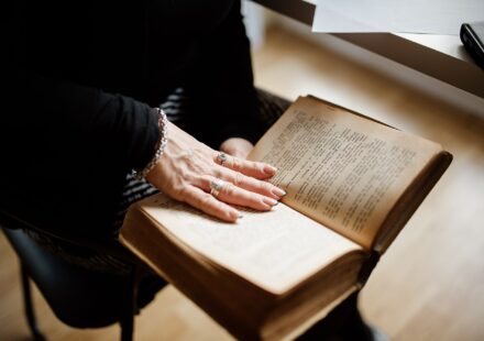 Business senior woman reading an old book at home closeup