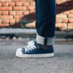 A close-up of a person wearing canvas sneakers