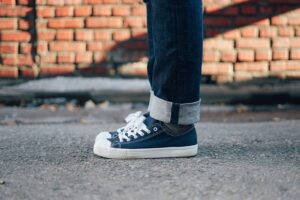 A close-up of a person wearing canvas sneakers