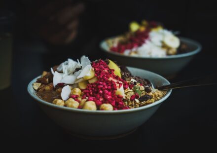A bowl of yogurt topped with fruit and seeds