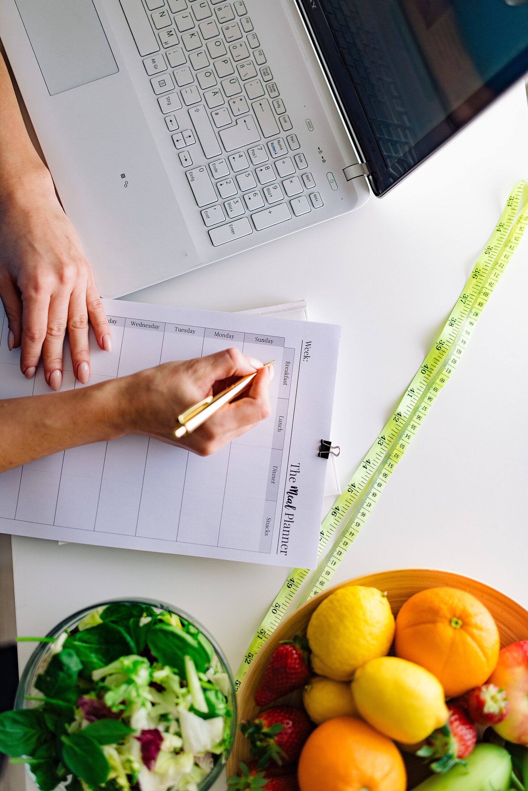 Person planning meals with a grocery list and fresh produce