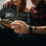 Senior couple sitting on a sofa and reading a book together